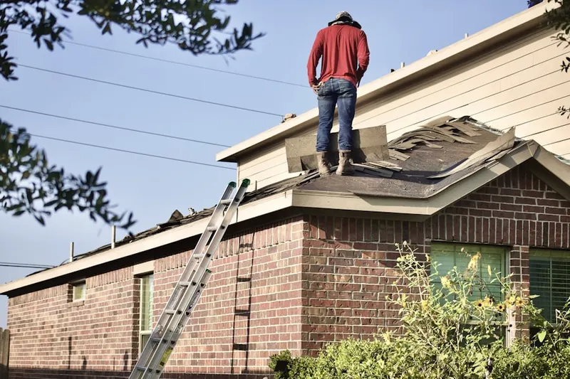 Professional roofer working on a residential roof in Winona Lake
